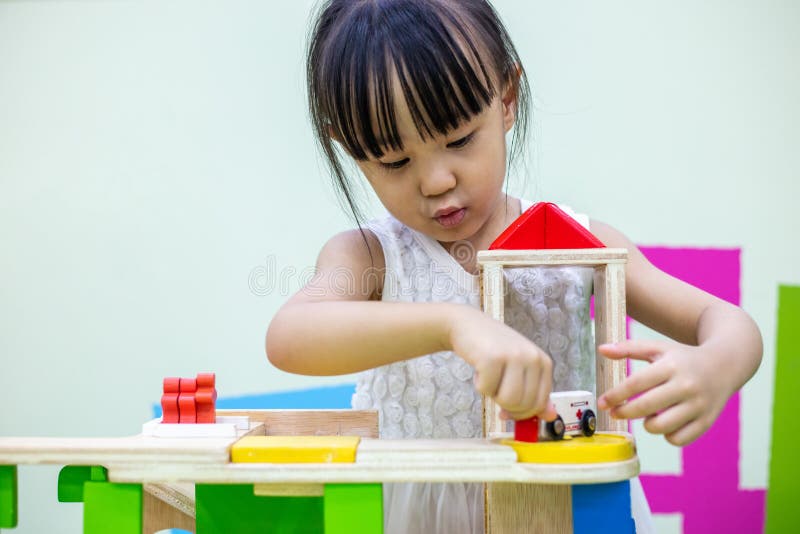 Asian Chinese little girl playing wooden toy train