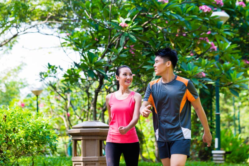 Asian Chinese man and woman jogging in city park stock photos Asian Chinese man and woman jogging in city park stock photos