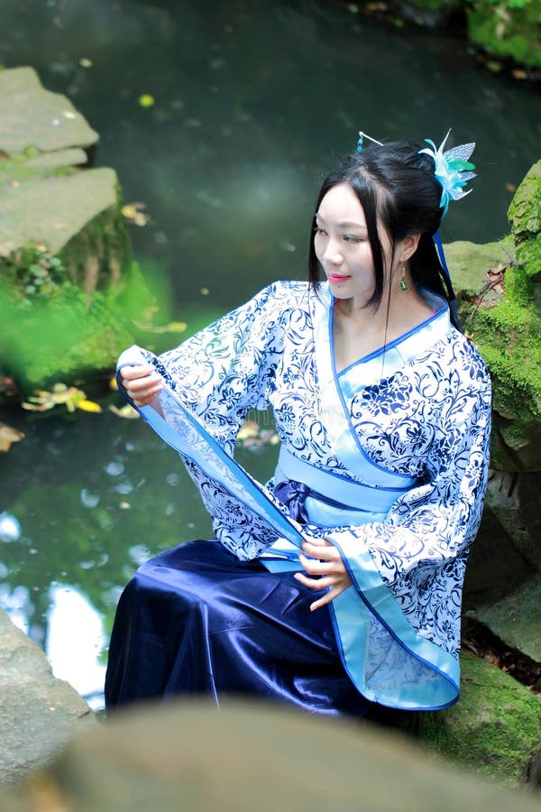 Asian Chinese Woman in Traditional Blue and White Hanfu Dress, Play in a Famous Garden Stock