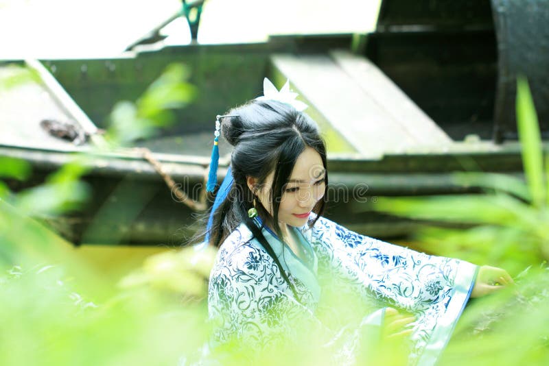 Asian Chinese Woman in Traditional Blue and White Hanfu Dress, Play in a Famous Garden Stock