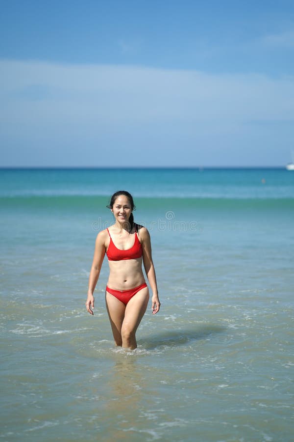 Asian Chinese Woman in walking at the beach with blue water