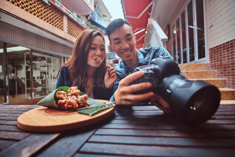 Asian couple enjoy chinese food and watching pictures