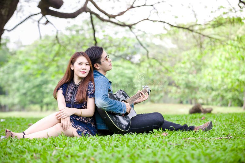 Outdoor shot of a romantic couple embracing outdoor. Beautiful young  brunette holding a guitar leaning head with closed eyes on her boyfriend  chest. Photos | Adobe Stock