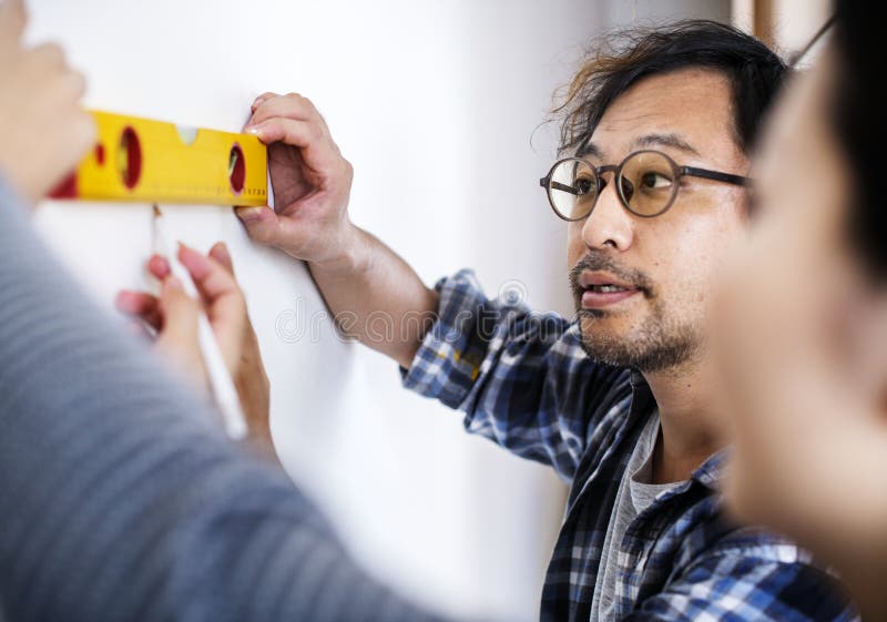 Asian couple measuring the wall royalty free stock photo