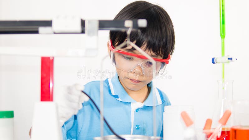 Asian cute child learning science in laboratory on gray whit background.