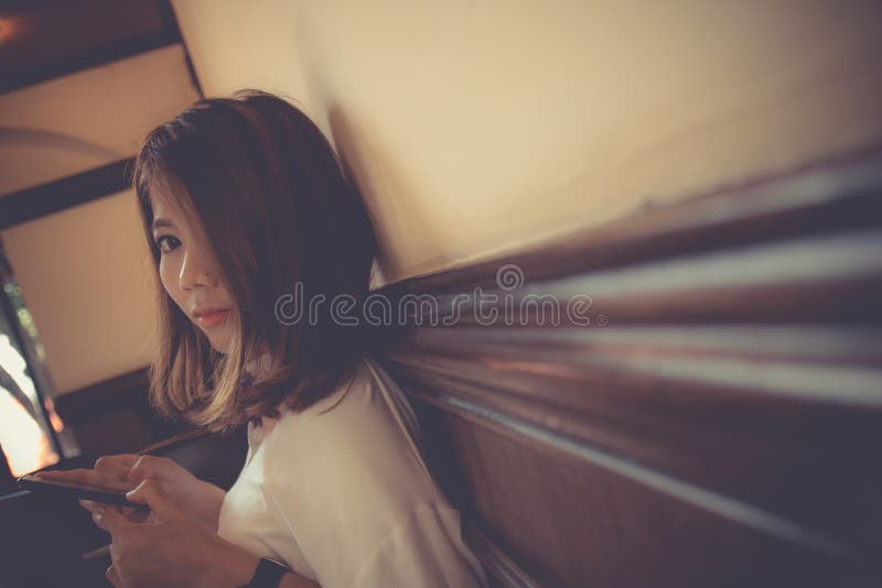 Asian cute girl use smart phone looking at camera royalty free stock image Asian cute girl use smart phone looking at camera royalty free stock image