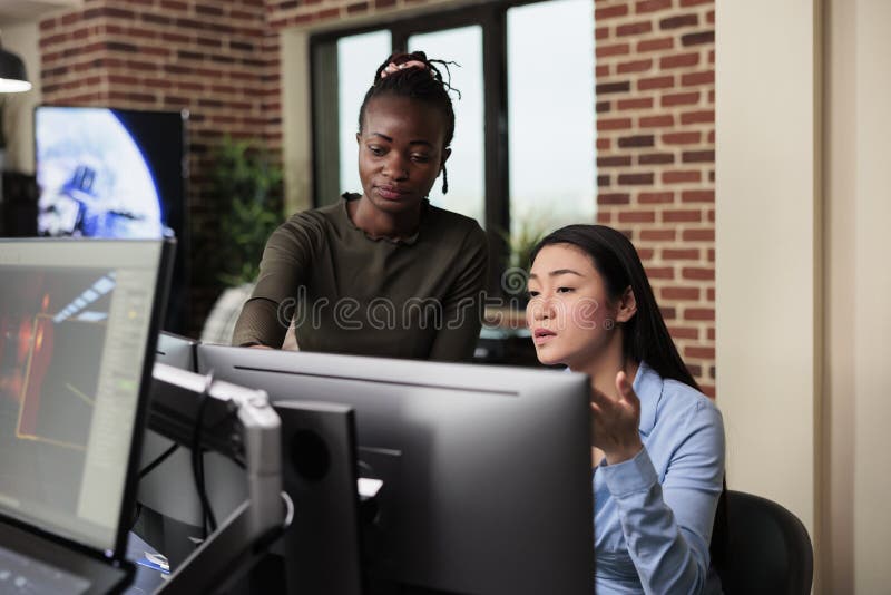Asian developer and african american colleague developing digital art using modelling software. royalty free stock photos