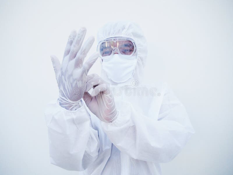 Asian doctor or scientist in PPE suite uniform putting on protective white gloves while looking hands. COVID-19 concept isolated stock photography