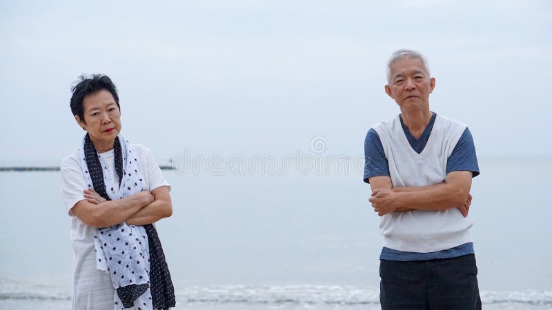 Asian elderly couple fight upset at ocean sea beach morning