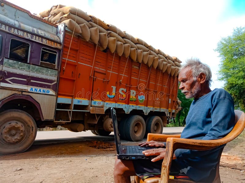 asian elderly man learning about laptop computer system at road side in india January 2020