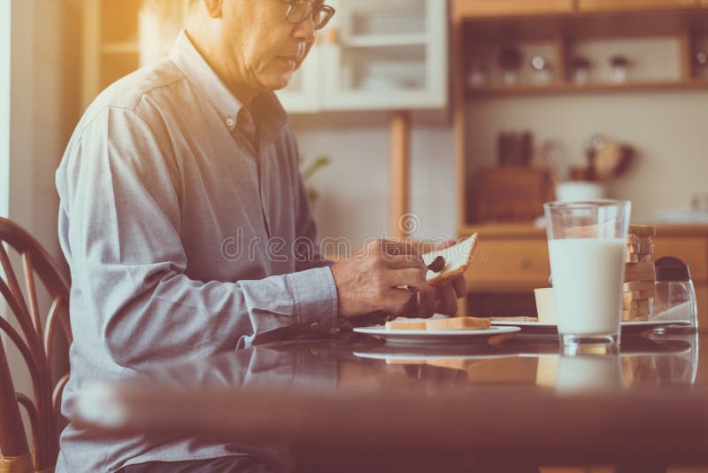 Asian elderly men preparing healthy food for breakfast with bread and butter,Retirement senior lifestyle living concept royalty free stock image Asian elderly men preparing healthy food for breakfast with bread and butter,Retirement senior lifestyle living concept royalty free stock image