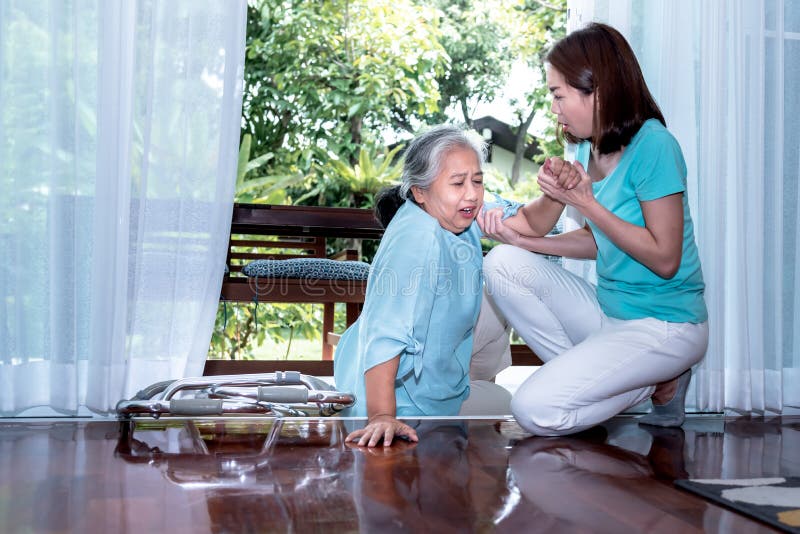 Asian elderly woman is patient from paralysis, is falling, laying down on the floor. An Asian elderly women is patient from paralysis, is falling, laying down on stock image