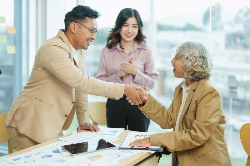 Asian entrepreneurs handshakes to congratulate the agreement between the two companies to enhance investment and