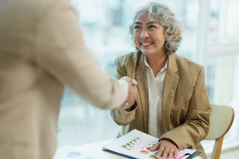 Asian entrepreneurs handshakes to congratulate the agreement between the two companies to enhance investment and