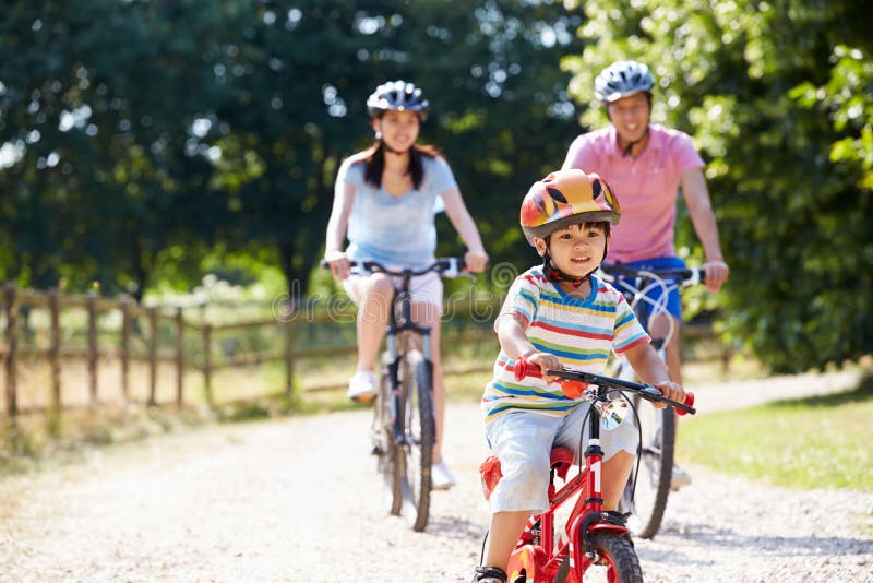 Asian Family On Cycle Ride In Countryside