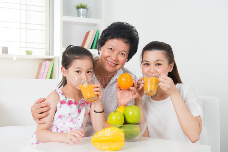 Asian family drinking orange juice.