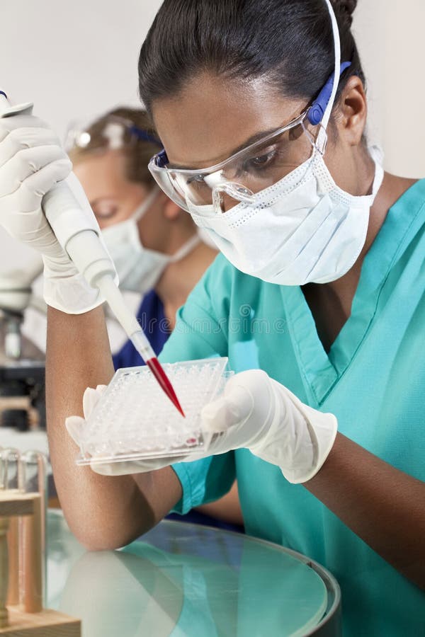Una mujer asiático médico o científico investigador o pipeta muestra bandeja sobre el sangre muestra en laboratorio su una mujer colega afuera de concentrarse para su.