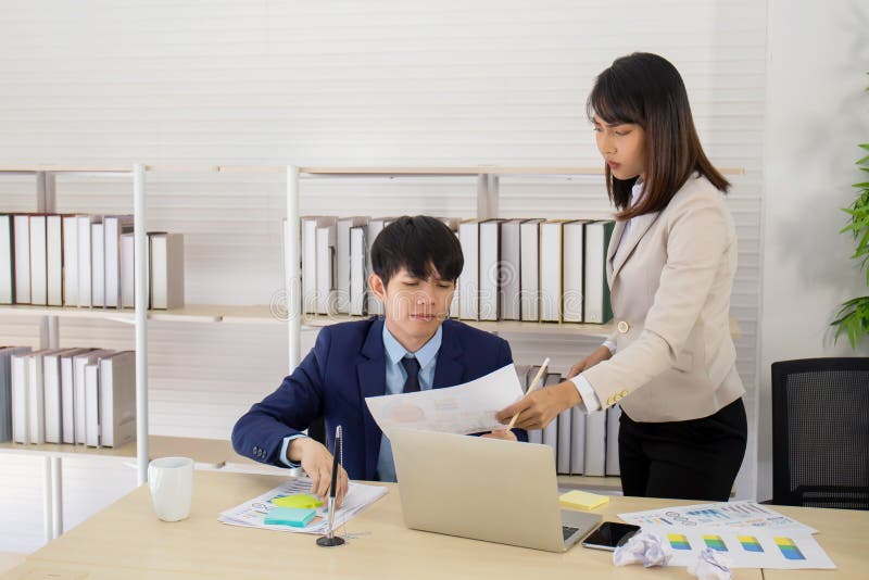 An Asian Female Supervisor Stands with a Young Male Employee on Her Desk with a Serious Face Stock Image - Image of chinese, collaboration: 176354701