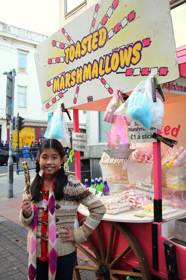 Asian female tourist enjoy traditional toasted marshmallows. royalty free stock photos Asian female tourist enjoy traditional toasted marshmallows. royalty free stock photos