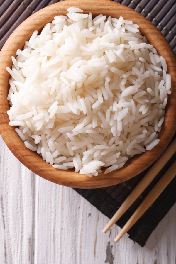 Asian food: rice in a wooden bowl closeup. vertical top view royalty free stock photography Asian food: rice in a wooden bowl closeup. vertical top view royalty free stock photography