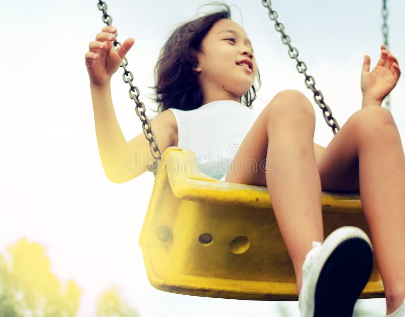 Asian girl children playing on the swing. stock photos Asian girl children playing on the swing. stock photos