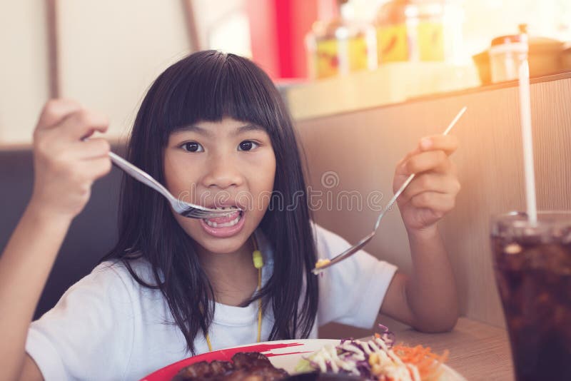 Asian girl eating chicken steak in restaurant.. royalty free stock photo Asian girl eating chicken steak in restaurant.. royalty free stock photo