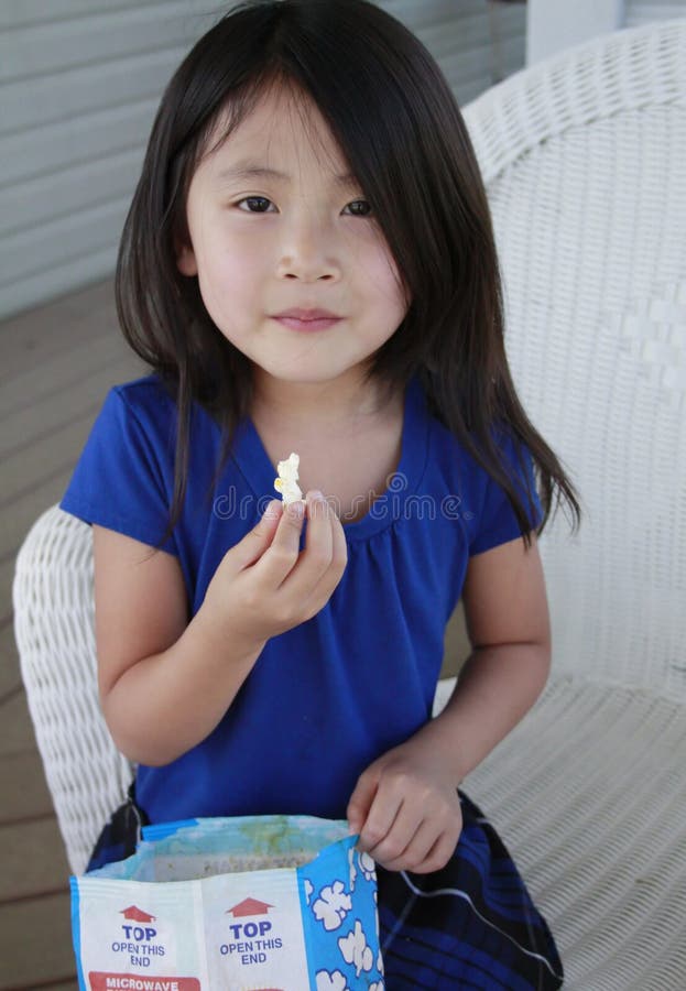 Asian girl eating popcorn