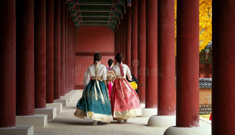 Asian girl in hanbok dress walk in autumn leaves park