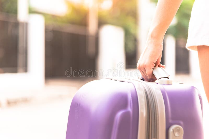Asian girl has holding big purple bag for come back from travel