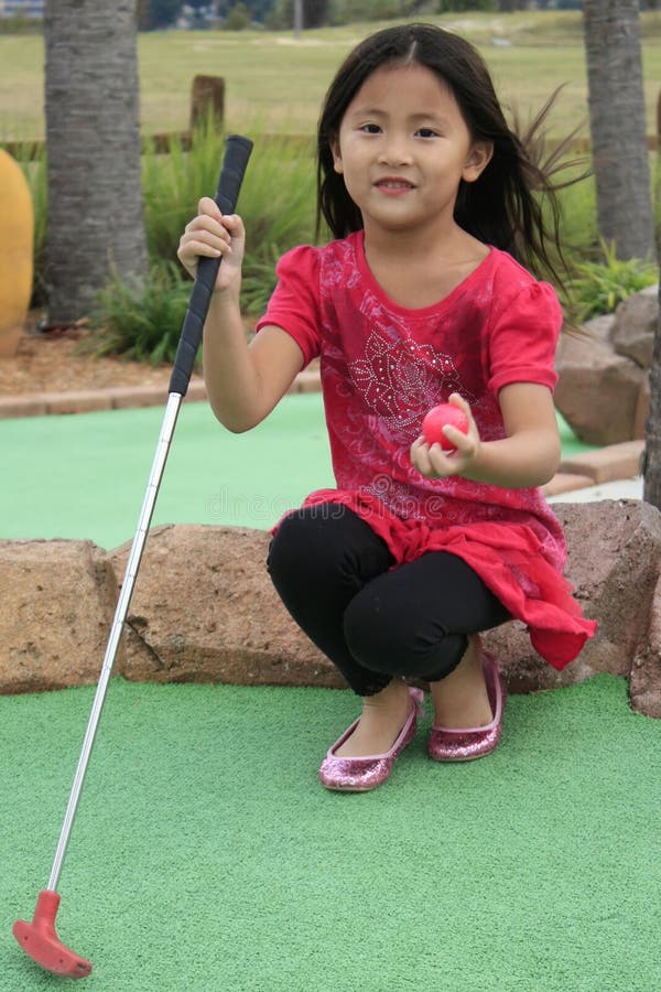 asian girl playing mini golf