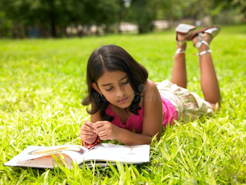 Asian girl reading a book in the park