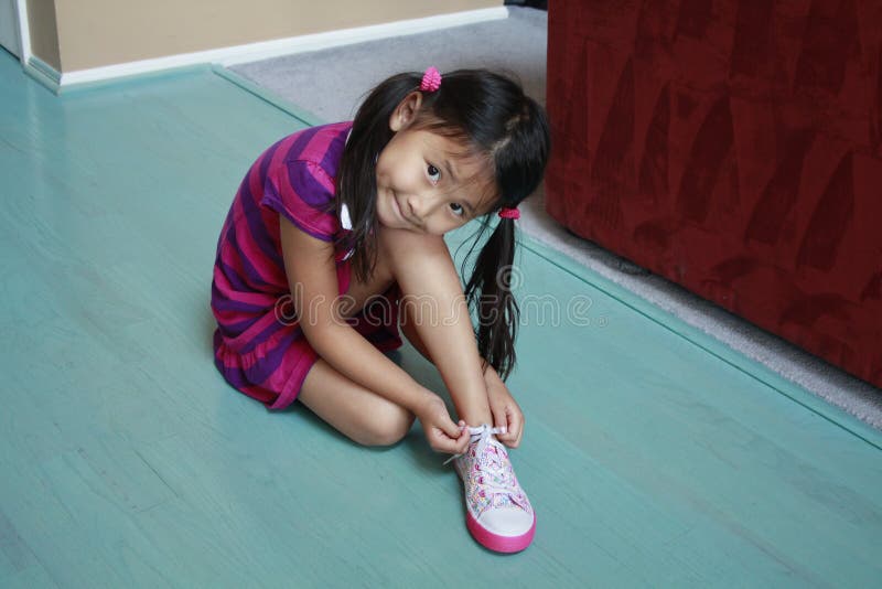 Asian girl tieing shoe