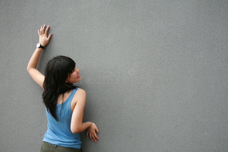 Asian girl touching wall