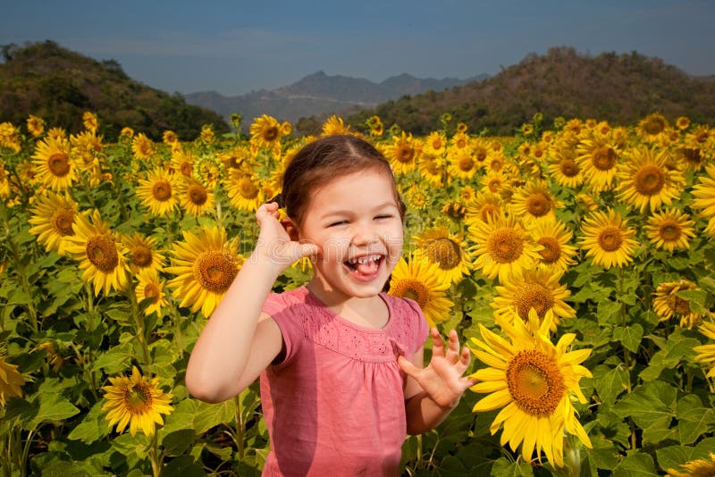 Asian girl walks in a field of sunflowers