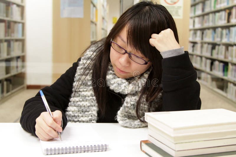 An Asian girl who is reading and studying