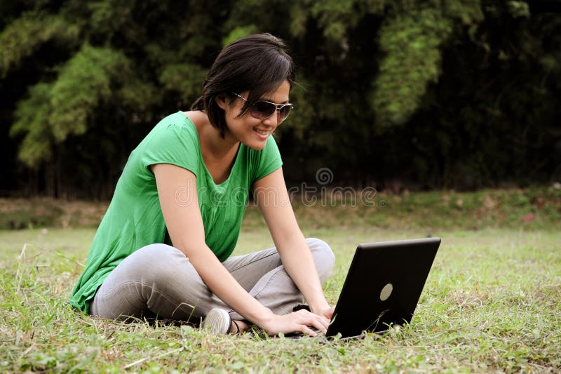 Asian girl writes an email outdoor