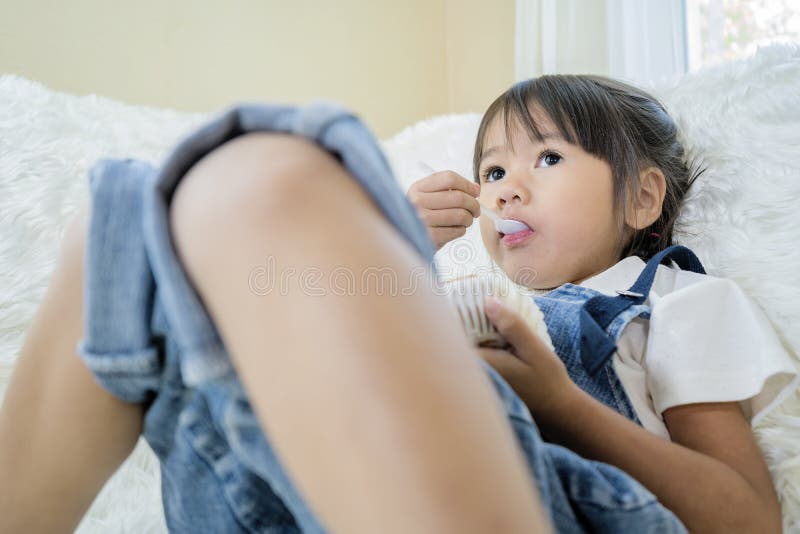 Asian girls are eating happily on a white sofa