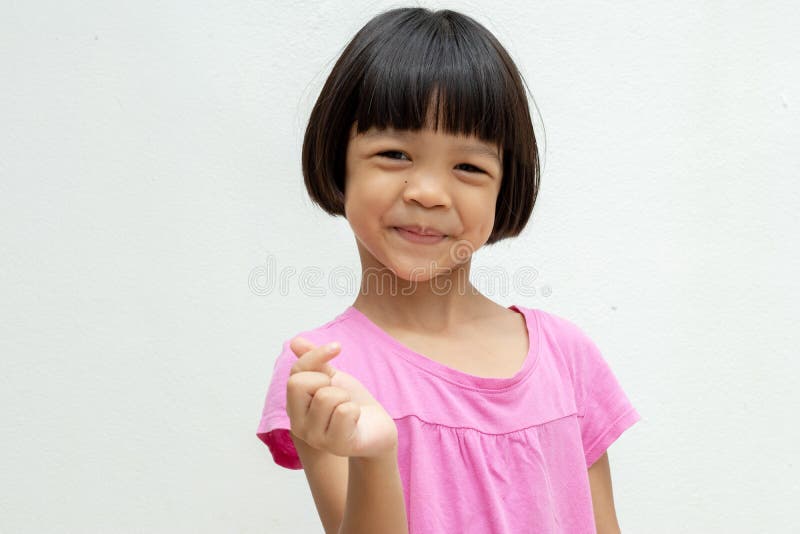 Asian Kid Girl Aged 4 To 6 Years Old with Short Hair, Cute Face and Smiling  Smile. Wear a Pink Shirt Raises the Right Hand and Stock Image - Image of  model, healthy: 200982153