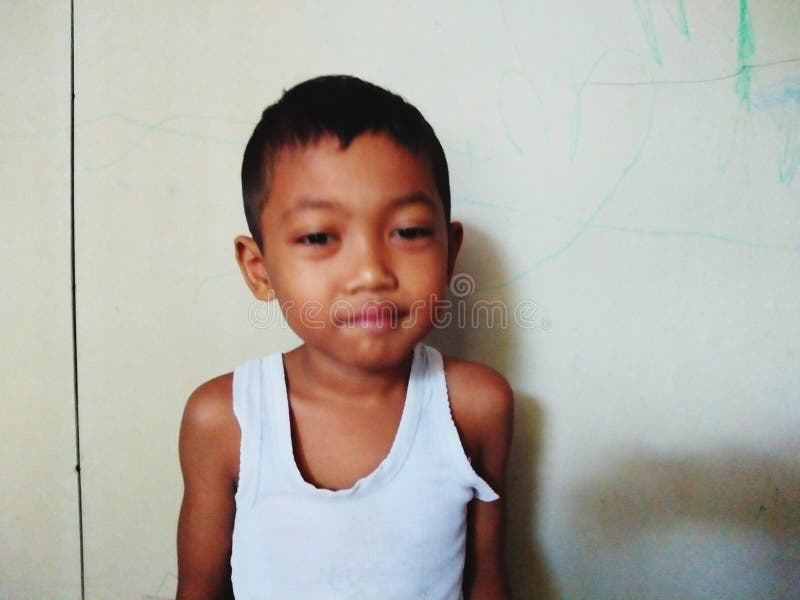 Asian Kid Looking at Camera Against Wall Background Stock