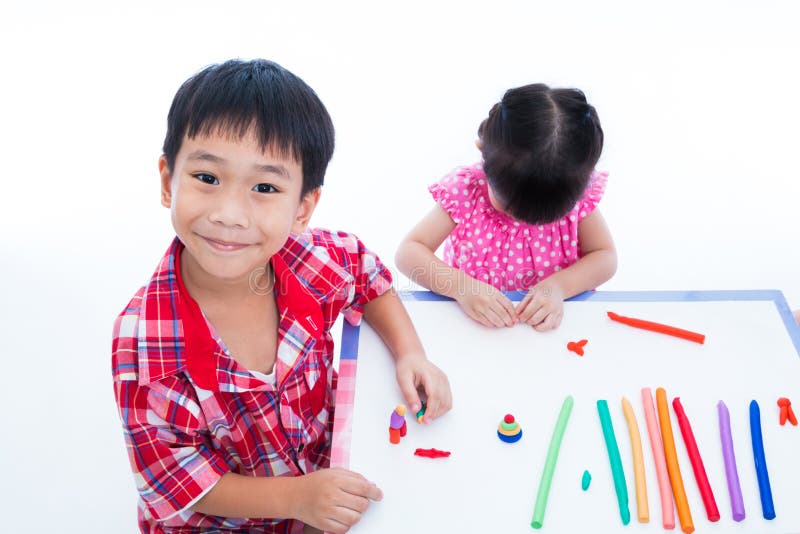 Asian kids playing with play clay on table. Strengthen the imagination