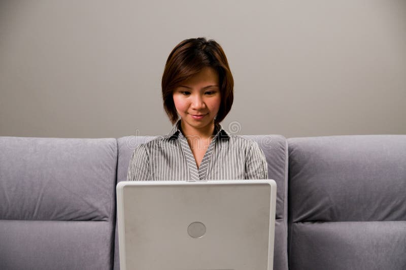 Asian lady in business attire, using a computer