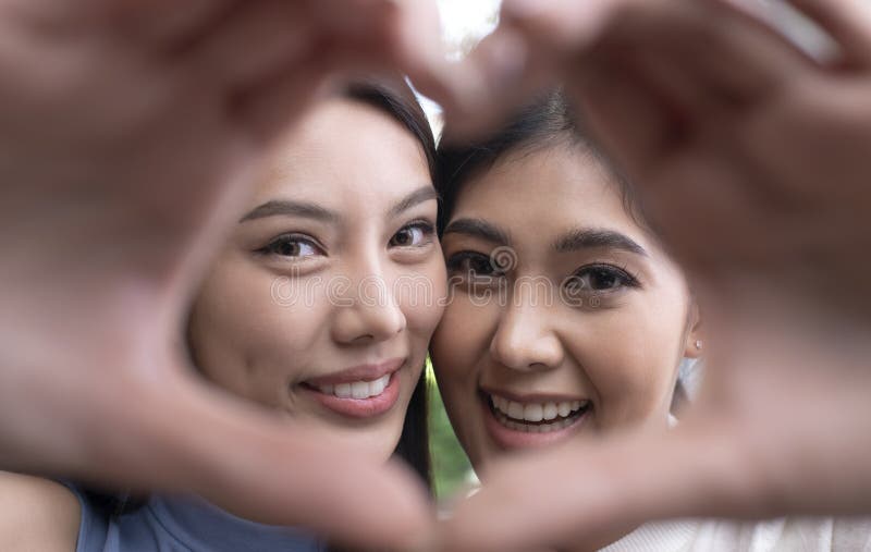 Asian Lesbian Couple In A Romantic Mood Making Heart Shaped Hand Gesture Lgbt Couple Showing