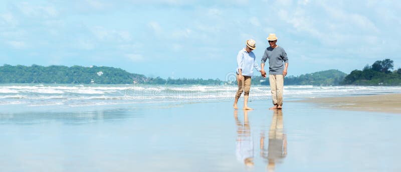 Asian Lifestyle Senior Couple Walking Chill And Pointing On The Beach