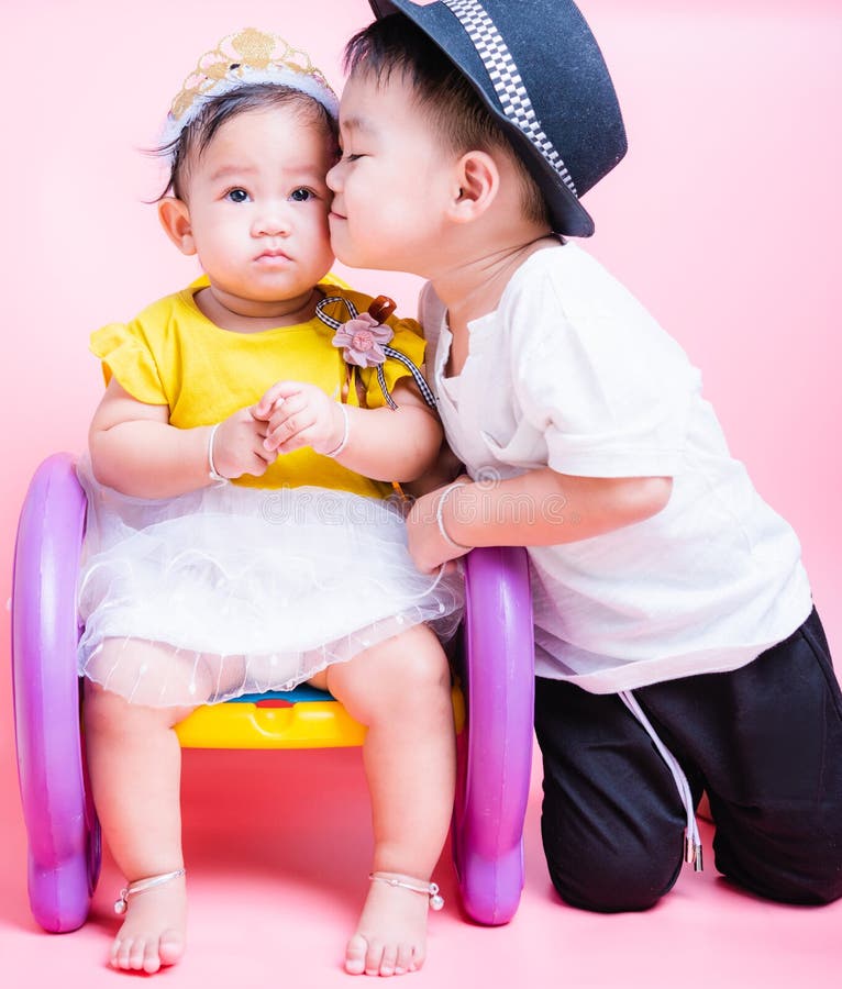 Asian Little brother and her baby girl in beautiful dress sitting on chair, Family with children in studio royalty free stock images Asian Little brother and her baby girl in beautiful dress sitting on chair, Family with children in studio royalty free stock images