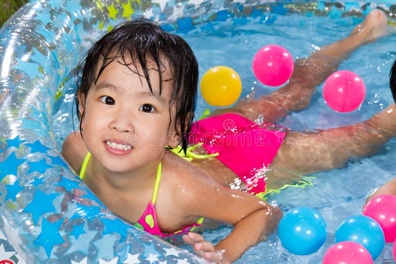 Asian Little Chinese Girl Playing in an Inflatable Rubber Swimming Pool
