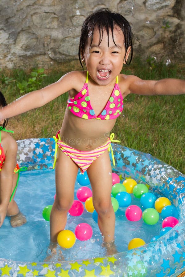 Asian Little Chinese Girl Playing in an Inflatable Rubber Swimming Pool