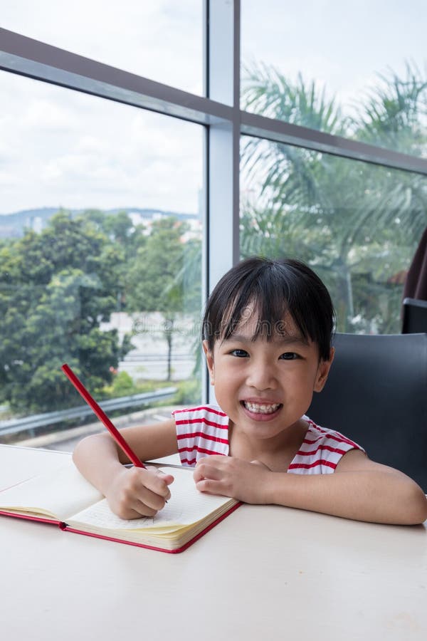 Asian little Chinese girl writing homework. Leisure, book.