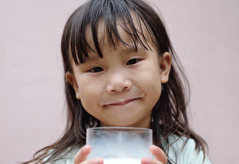 Asian little girl is smiling and eating milk. royalty free stock photos Asian little girl is smiling and eating milk. royalty free stock photos