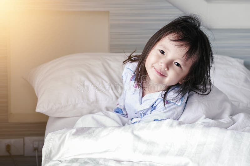 Asian Little girl wakes up from sleep.Good morning at home ,selected focus