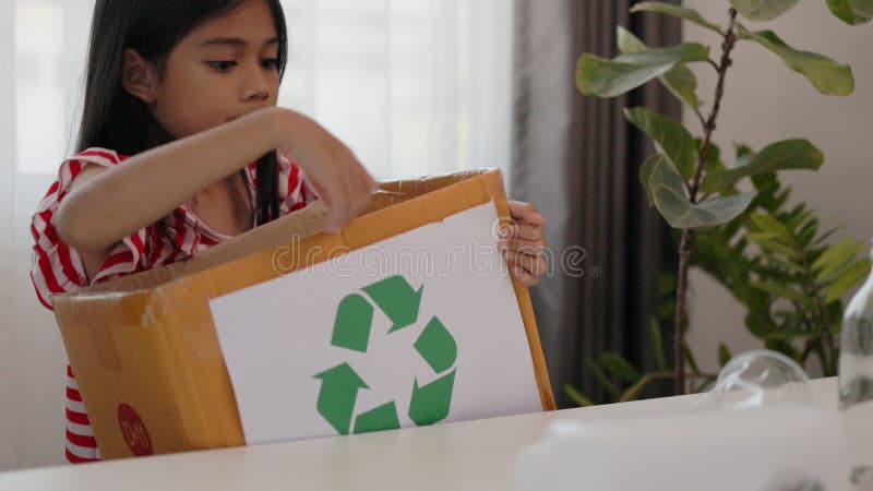 Asian little Girls dump plastic bottles in recycling boxes to reduce trash, reuse, and recycle. Recyclability and sustainability stock photo